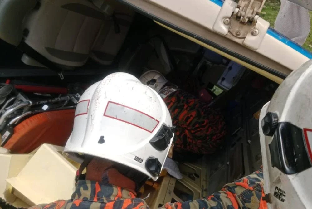 Anggota bomba membantu mengeluarkan mangsa dari ambulans yang terlibat nahas pada Selasa. Foto: JBPM