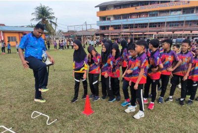 Nazmizan (kiri) ketika mengendalikan klinik Olahraga Perdana Peringkat Negeri Terengganu di Sekolah Kebangsaan (SK) Gong Kapas pada Oktober lalu.