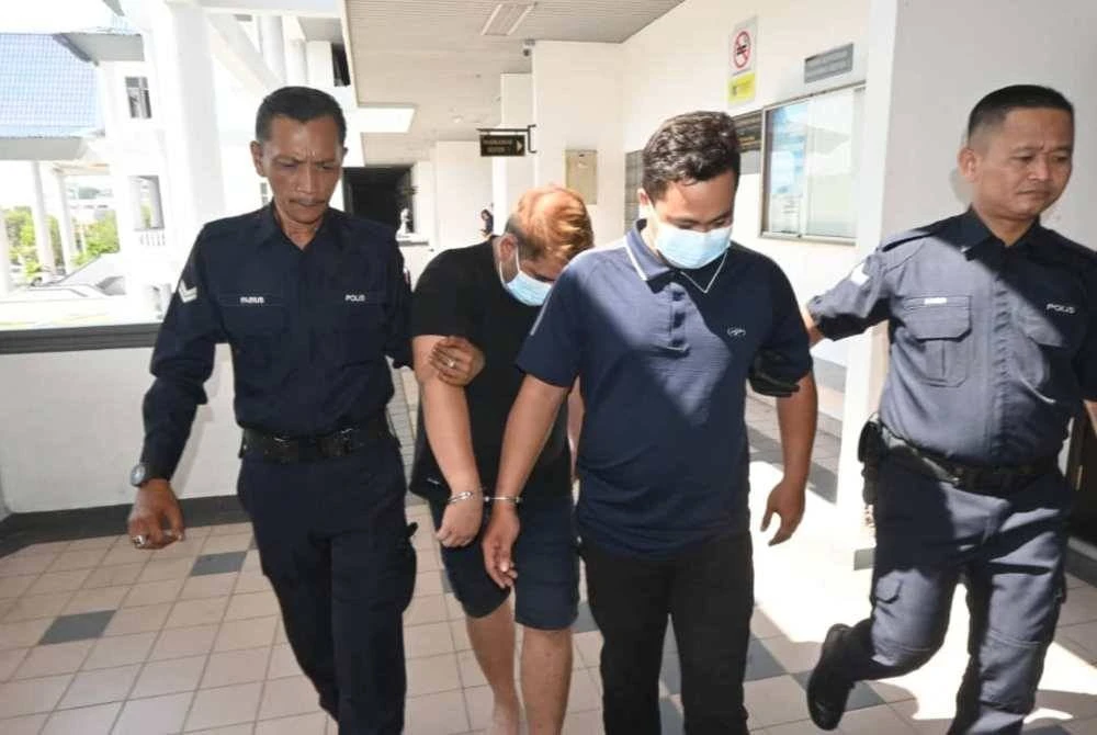 Muhamad Zulhilmi (dua dari kanan) dan Muhammad Shahirul Azri dibawa keluar dari Mahkamah Majistret Melaka pada Rabu.