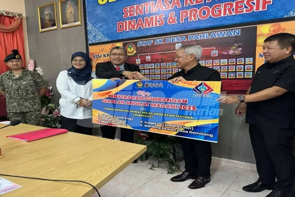 Amir (dua dari kanan) menyerahkan simbolik sumbangan kepada Wan Mohd Abd Malik (tiga dari kiri) di Sekolah Kebangsaan Kem Desa Pahlawan, Kota Bharu pada Rabu. 
•Foto:SINAR HARIAN/ADILA SHARINNI WAHID