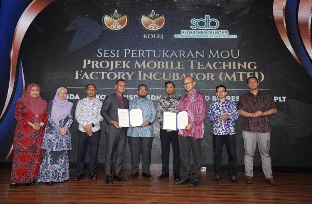 Manndzri (tengah) menyaksikan pertukaran dokumen Projek Mobile Teaching Factory Incubator (MTFI) pada majlis Perasmian Seminar Agropreneur Risda Tahun 2025.
