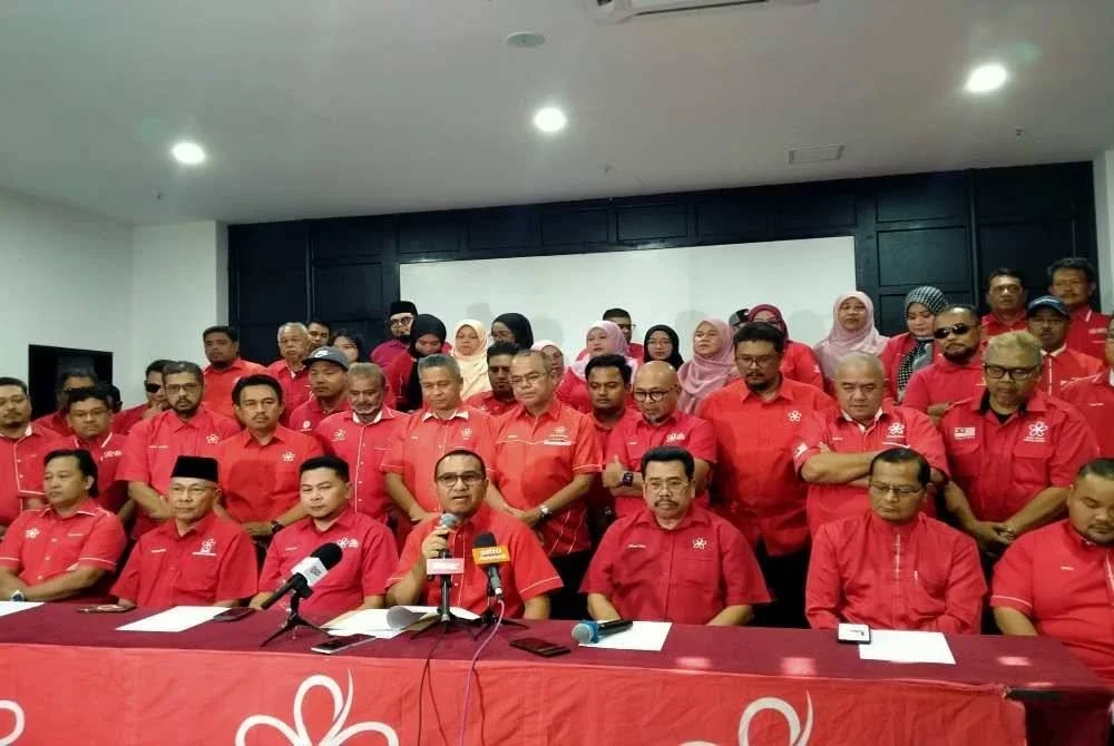 Zainol Fadzi (duduk, empat dari kanan) mengetuai sidang media bersama 14 ketua dan jawatankuasa bahagian Bersatu di Perak di sebuah hotel di Ipoh pada Rabu.