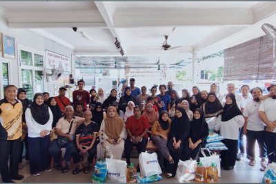 Maziah (berdiri, dua dari kiri) bersama penerima sumbangan Mercy Malaysia selepas penyampaian pek makanan tersebut di Rumah Ngaji Teluk Muro di Lumut baru-baru ini.