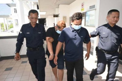 Muhamad Zulhilmi (dua dari kanan) dan Muhammad Shahirul Azri dibawa keluar dari Mahkamah Majistret Melaka pada Rabu. 