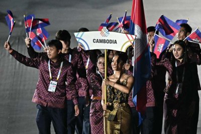 Delegasi Kemboja mengibarkan bendera kebangsaan mereka ketika menyertai acara perarakan atlet ketika upacara pembukaan Sukan SEA ke-33 di Stadium Nasional Rajamangala di Bangkok pada Selasa. Foto AFP