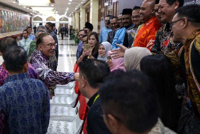Anwar (kiri) beramah mesra dengan orang ramai ketika hadir pada Majlis Makan Malam sempena Konvensyen Kongress Tritahunan Cuepacs ke-30 di Pusat Dagangan Dunia Kuala Lumpur pada Rabu. Foto: Bernama 