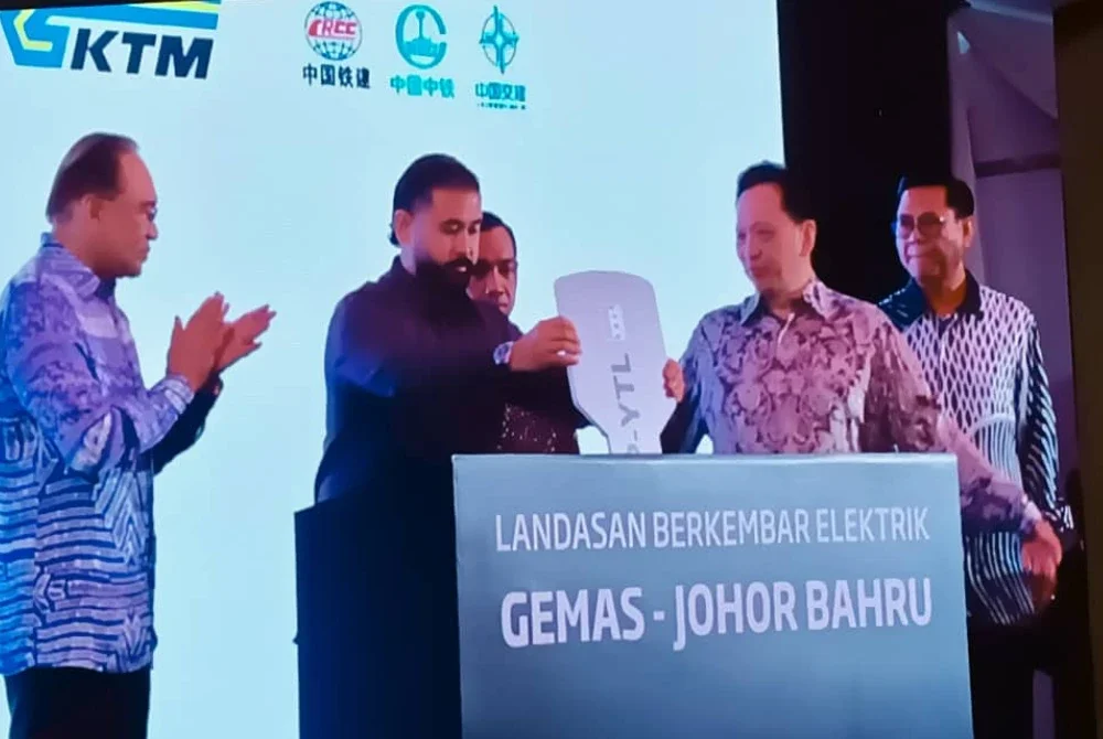 Tunku Ismail (dua dari kiri) mencemar duli menyempurnakan Majlis Penyempurnaan dan Pengoperasian Landasan Berkembar Elektrik Gemas–Johor Bahru di Stesen KTMB Kempas Baru pada Khamis.