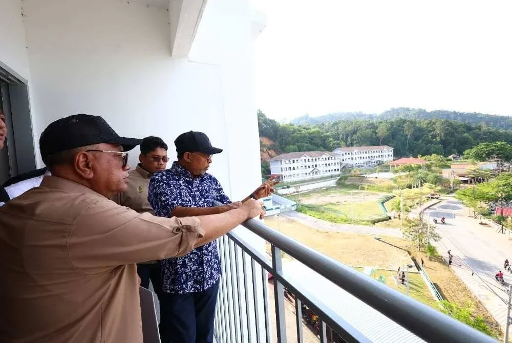 Zambry (kanan) bersama Mohd Zolkafly (kiri) meninjau pemandangan dari bangunan PSN Pulau Pangkor di Teluk Gedung pada Khamis.