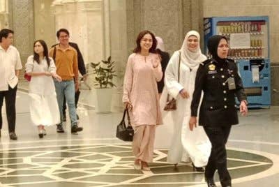 Bella (tiga dari kanan) kelihatan yang kelihatan anggun dan manis mengenakan baju kurung bewarna pink turut ditemani pembantunya.