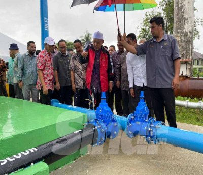 Ahmad (tiga dari kanan) memeriksa air semasa sesi Lawatan Kerja ke Tapak Tangki Kampung Laut di Tumpat pada Khamis.