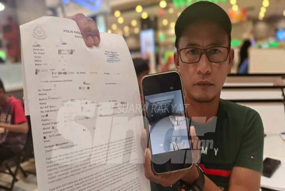 Mohd Zaidi menunjukkan laporan polis dan gambar kilang
