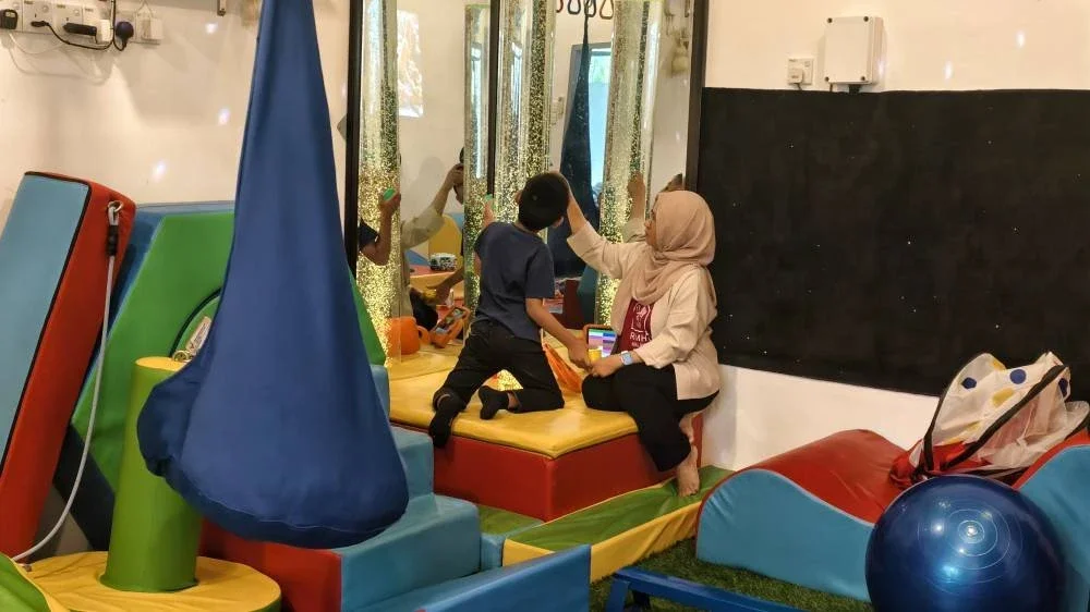 Juruterapi Bilik Terapi Sensori Ronald McDonald di Tampin, Azimah Norsham menjalankan sesi terapi kepada seorang kanak-kanak istimewa.