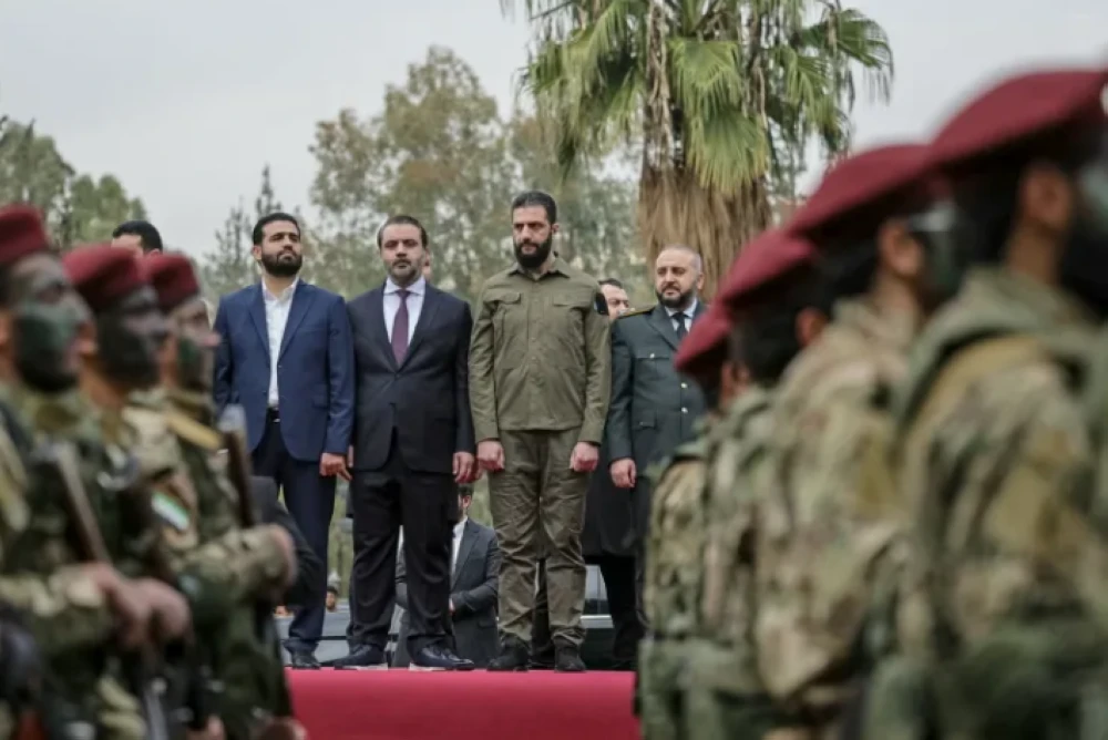 Al-Sharaa (tengah) bersama beberapa menteri di bawah pentadbirannya menyaksikan acara perarakan pasukan badan beruniform di Damsyik.