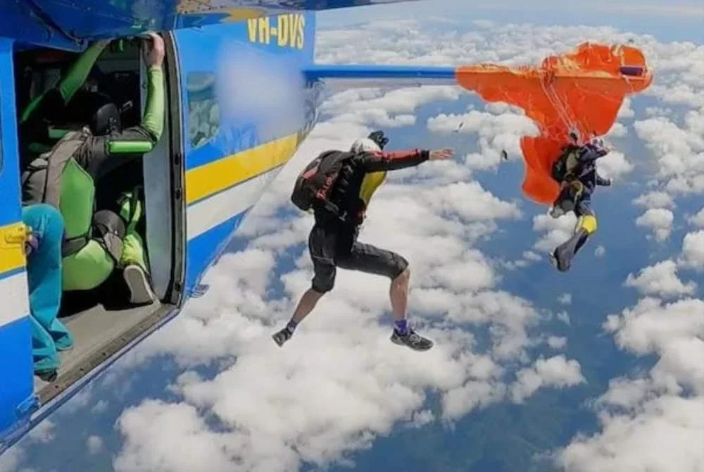 Seorang penerjun tergantung di udara selepas payung terjunnya tersangkut pada bahagian sayap pesawat dalam kejadian di Australia pada 20 September 2025. Foto ATSB