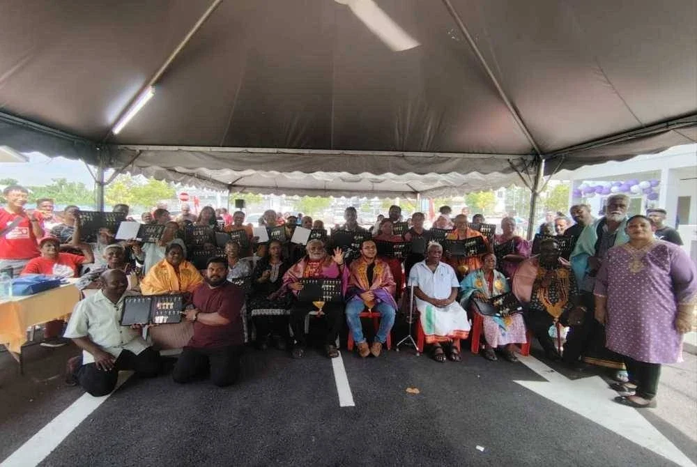 S Arutchelvan (duduk di tengah) bersama wakil penduduk dan penerima serta wakil pihak Sime Darby. 