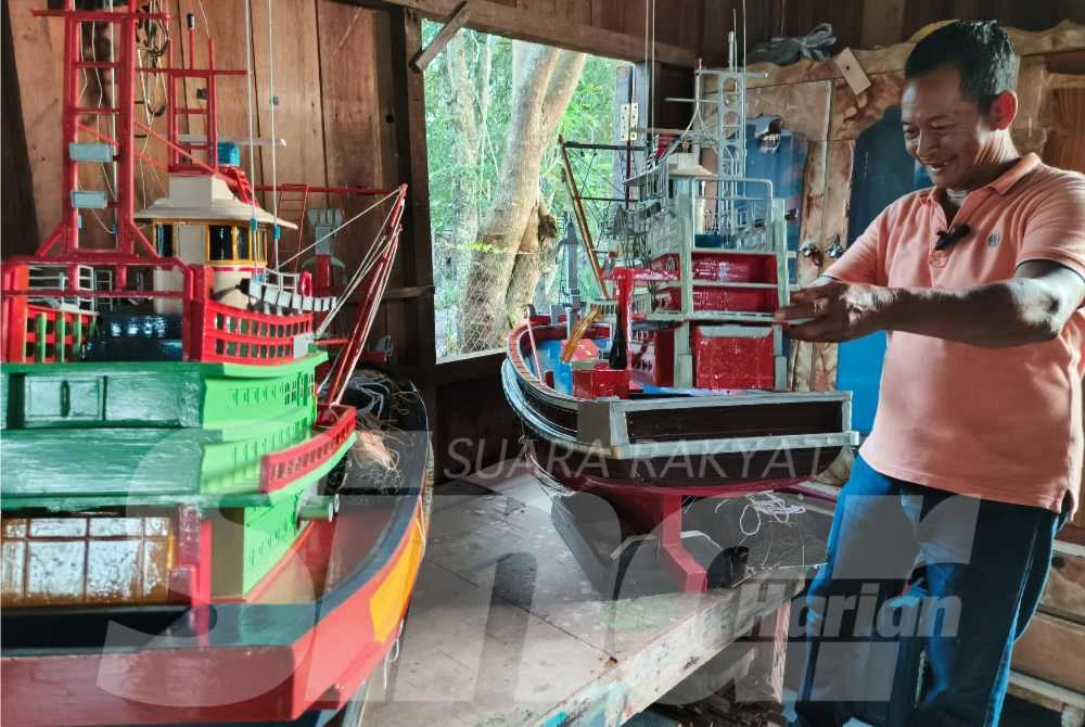 Engku Abbas menunjukkan replika bot model Kelantan (kanan) dan Terengganu (kiri), hasil seni pertukangan tradisi yang disiapkan dengan teliti di bengkel beliau di Kampung Beris, Alur Pisang di Kuala Besut.