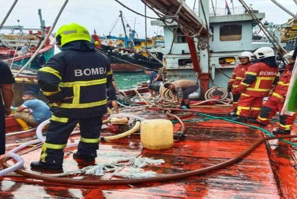 Anggota bomba memadam kebakaran membabitkan sebuah bot di Kompleks Perikanan Lembaga Kemajuan Ikan Malaysia (LKIM) Endau. -Foto JBPM Johor 