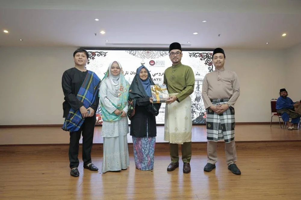 Syamsul Hazeman (dua dari kanan) menerima lima naskhah komik daripada Anida (tiga dari kiri) sempena Program Santun Menerusi Komik dan Naratif Rakyat di Kompleks Islam Darul Ridzuan, Ipoh pada Isnin.