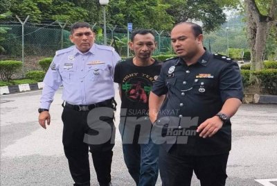 Pihak polis membawa Noor Azuan (tengah) ke Mahkamah Majistret Shah Alam pada Isnin.
