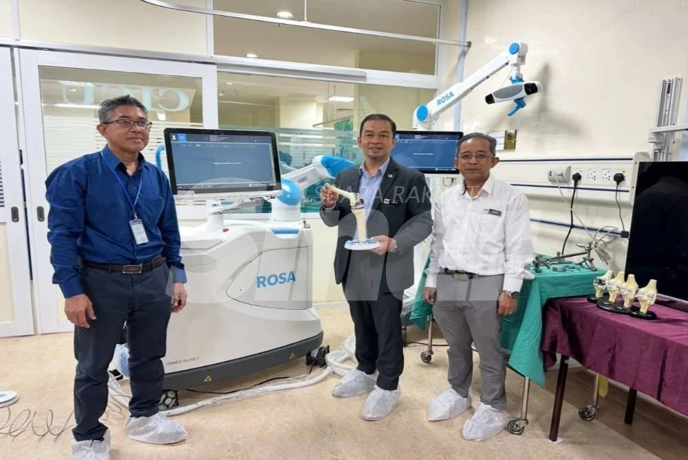 Dr Mohd Azman (tengah) menunjukkan model lulut dipasangkan implan.