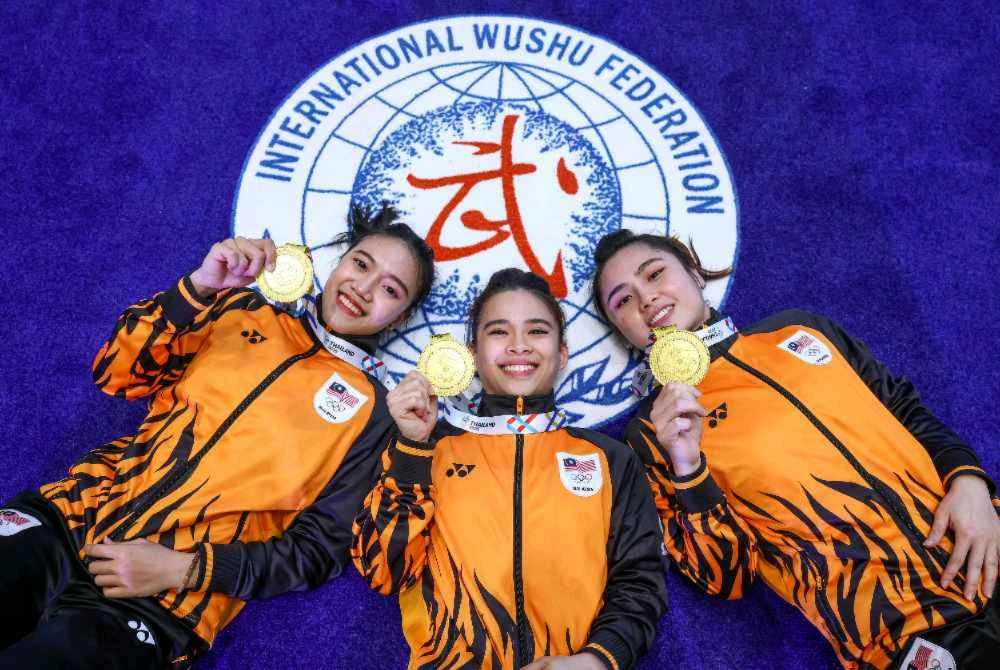(Dari kiri) Pui Yee, Cheong Min dan Ying Ting bersama pingat emas yang dimenangi pada acara akhir wusyu duilian bersenjata wanita pada Sukan SEA 2025 di bangunan Ratthaprasasanphakdi pada Isnin. Foto Bernama