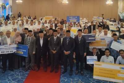 Syed Anwar (empat dari kiri), Ambrin (lima dari kiri) dan Mohd Khaidzir (enam dari kiri) bergambar kenangan sempena Majlis Iktiraf Muzakki dan Penyerahan Zakat (Imtiyaz) pada Selasa.