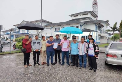 Md Israk (empat dari kanan) menunjukkan laporan polis yang dibuat Ibu Pejabat Polis Daerah (IPD) Pontian pada Selasa. 