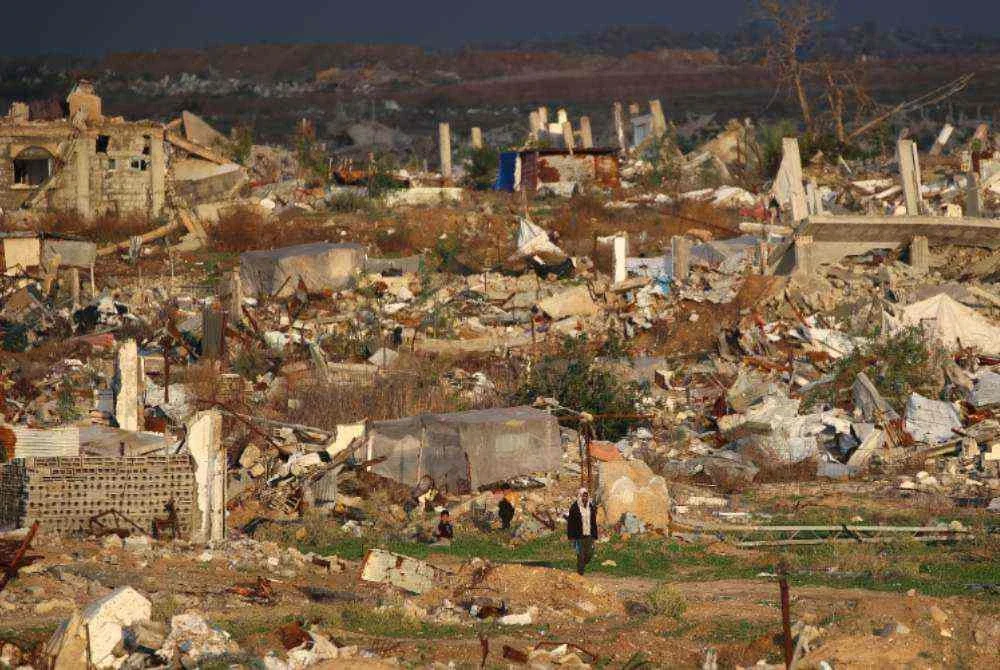 Seorang lelaki berjalan melepasi rumah dan bangunan yang musnah akibat serangan tentera Israel di kem pelarian Nuseirat, Gaza Tengah. Foto AFP
