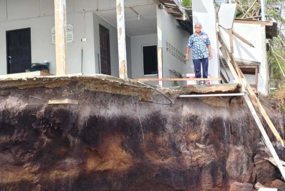 Zulkefli menunjukkan keadaan surau Pantai Pengkalan Maras yang diancam masalah hakisan pantai.