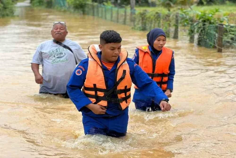 APM Daerah Machang meredah banjir 0.5 meter sejauh satu kilometer bagi membantu seorang pesakit strok di Kampung Temangan, Machang. Foto: APM