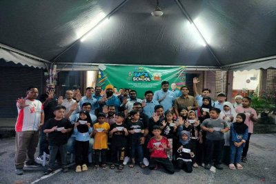 Ashraf (duduk, tengah) bersama penerima sempena Program Back To School AMK Perak di Pejabat Parti Keadilan Rakyat (PKR) Cabang Ipoh Barat di sini pada Selasa.