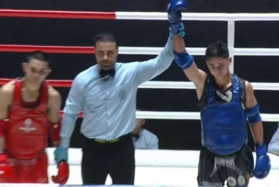 Miki (kanan) meraih emas Muay Thai kategori 57kg pada Rabu.