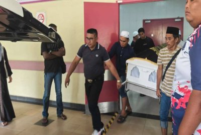 Jenazah Allahyarham dibawa keluar selepas selesai proses bedah siasat di Hospital Alor Gajah pada Rabu.
