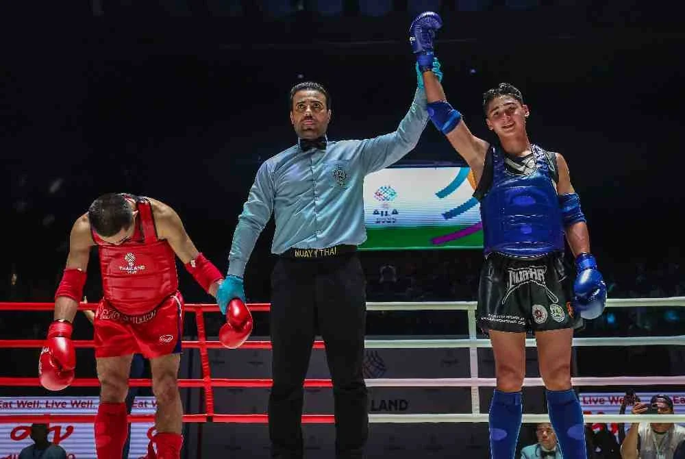 Miki (kanan) diisytiharkan pemenang pingat emas kategori 57 kilogram Muay Thai selepas menewaskan Suphakon Sirilun pada Sukan SEA Thailand 2025 di Stadium Lumpinee, Bangkok pada Rabu. Foto Bernama