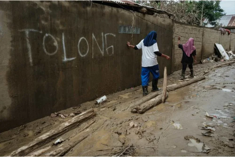 Sebuah dinding di kawasan terjejas banjir tertera tulisan 'tolong' selepas ramai mangsa banjir merayu bantuan sejak lebih dua minggu lalu.