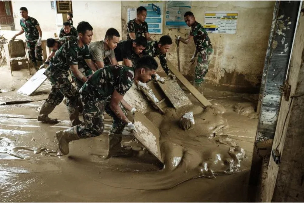 Anggota tentera membantu operasi pembersihan sisa lumpur yang sedang giat dilakukan di kebanyakan lokasi di Sumatera Utara.