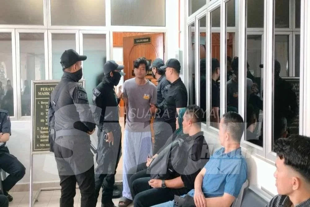 Tertuduh diiringi polis ketika dibawa ke Mahkamah Bukit Mertajam, pada Khamis.