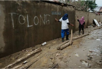 Sebuah dinding di kawasan terjejas banjir tertera tulisan 'tolong' selepas ramai mangsa banjir merayu bantuan sejak lebih dua minggu lalu.