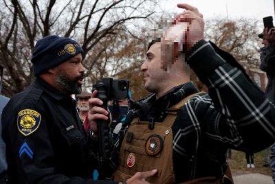 Anggota polis cuba menghalang tindakan Lang (kanan) yang cuba membakar al-Quran di Michigan pada bulan lalu. - Foto Agensi