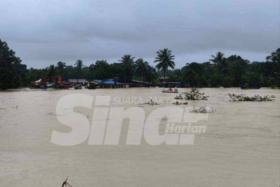 Penduduk kampung Sri Damai menaiki bot selepas kediaman mereka dinaiki air.