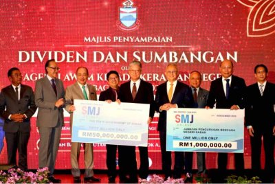 Hajiji (tiga dari kiri) menerima replika cek daripada SMJ Energy Sdn Bhd di Kota Kinabalu.