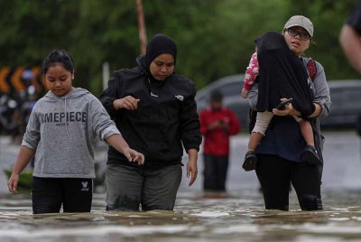 Penduduk terpaksa meredah banjir sekitar kawasan Taman Guru, Kuantan susulan hujan berterusan yang menyebabkan limpahan dari Sungai Belat ketika tinjauan hari ini. Foto Bernama
