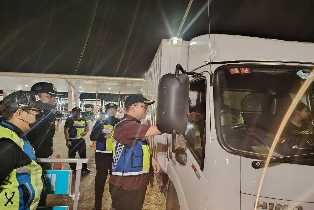 Azrin (kanan) memeriksa kenderaan perdagangan semasa Op Khas Bersepadu di Plaza Tol Sungai Ramal, Kajang pada Khamis.