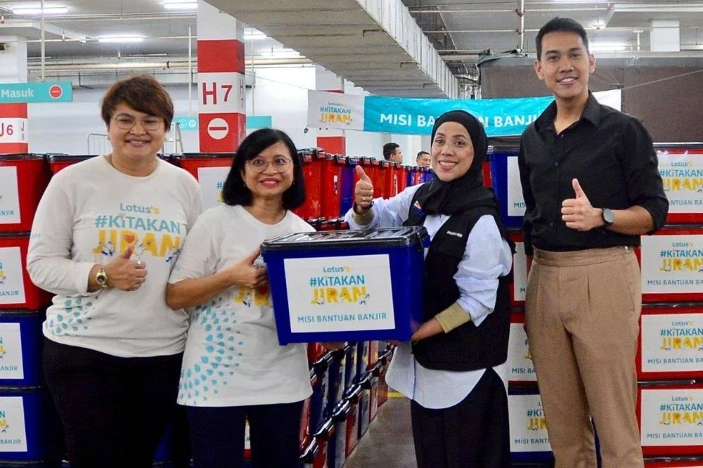 Azliza (dua dari kiri) menyerahkan kotak bantuan banjir kepada Sharifah Nor.