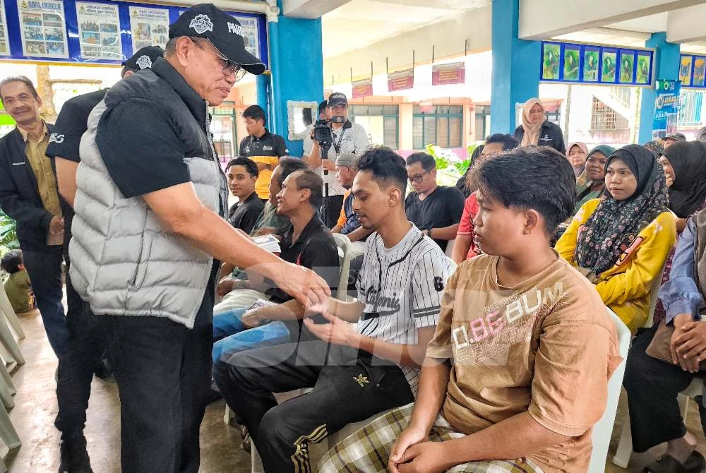 Wan Rosdy menyampaikan sumbangan kepada mangsa banjir di PPS SMK Bukit Rangin pada Jumaat. 