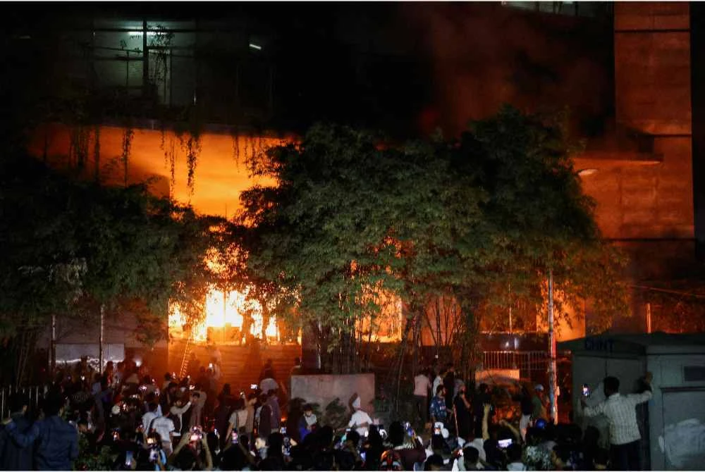 Penunjuk perasaan bertindak menyekat jalan raya serta membakar beberapa bangunan termasuk dua pejabat akhbar di ibu negara, Dhaka - Foto: Reuters