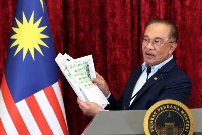  Anwar memperlihatkan senarai jemaah menteri baharu Kerajaan Madani ketika sidang media khas Pengumuman Anggota Kabinet Baharu di Bangunan Perdana Putra. Foto Bernama