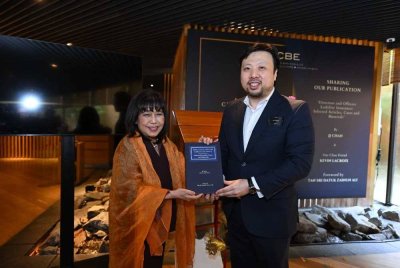 Zainun (kiri) dan JJ Chan bersama buku Directors & Officers Liability Insurance: Selected Articles, Cases and Materials yang diterbitkan khusus bagi tujuan akademik.