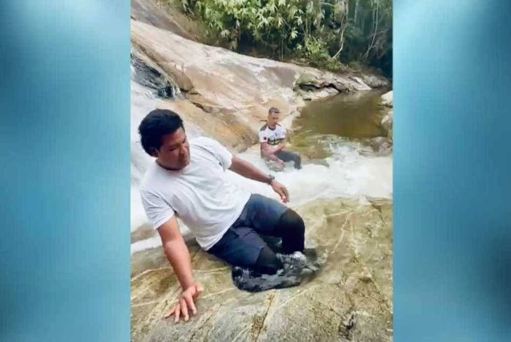Nik Ali (kiri) sedang masuk untuk mandi dalam telaga.