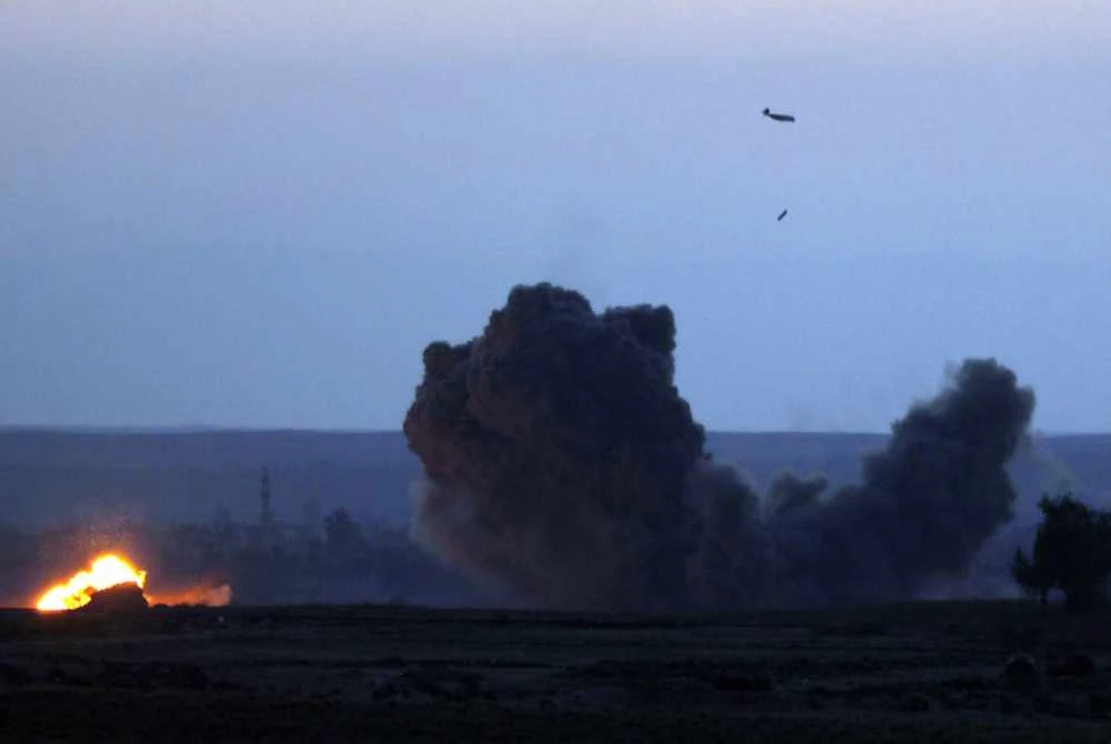 Sebuah pesawat tentera gabungan disokong Amerika Syarikat (AS) menggugurkan bom ke atas perkampungan Baghouz di wilayah Deir Ezzor, utara Syria. - AFP